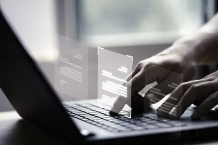 mains écrivant sur un clavier avec des écrans virtuels qui s'affichent devant